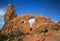 Hiker resting at Turret Arch at Arches National Park Moab Utah.