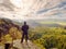 Hiker on rock end above valley. Man watch over misty and autumnal morning valley to bright morning nowhere.