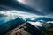 A hiker\\\'s view from a high mountain ridge, with jagged peaks and dramatic cloud formations in the distance