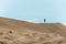 Hiker among sand dunes in the desert.