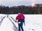 Hiker in Santa Claus costume walking in winter landscape.