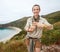 Hiker showing hashtag gesture in front of ocean view landscape