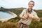 Hiker showing hashtag gesture in front of ocean view landscape