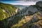 Hiker sits on a cliffs edge above the Big Crimea Canyon