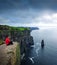 Hiker sitting at the cliffs of Moher