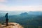 Hiker stand on the sharp corner of sandstone rock in rock empires park and watching over the misty and foggy morning valley to Sun