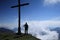 Hiker is standing near a cross