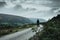 A hiker standing on a road in the Welsh Mountains with a mysterious, sinister composition