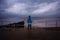 Hiker standing by the sea on a stormy day