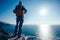 Hiker standing on sunrise seaside mountain cliff edge