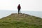 A hiker standing on top of a hill, looking out to sea, Baggy Point, Devon, UK