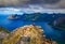 Hiker standing on the top of Husfjellet Mountain on Senja Island in Norway