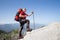 Hiker standing on top of the mountain with valley on the background.