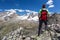 A hiker takes a rest looking at mountain panorama. Gran Paradiso National Park, West Alps, Val d`Aosta, Italy