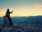 Hiker takes selfie photo. Man sit on Austria Germany border stone on Alpine mountain.