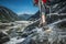 Hiker on a Trail in Waterproof Hiking Shoes Crossing Small Stream