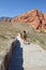 A hiker treks up a mountain path at Red Rock Canyon