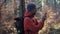 Hiker use smartphone for navigation in woods during autumn outdoor hiking expedition. Traveler using GPS navigational