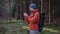 Hiker use smartphone for navigation in woods during autumn outdoor hiking expedition. Traveler using GPS navigational