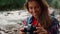 Hiker using photo camera. Smiling woman taking photos of mountain landscape