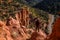 Hiker with vest standing on precarious edge of red rock cliff in southern Utah canyon