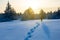 Hiker walk among a snowbound plain at the sunset