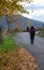 Hiker walking along an asphalt road in the Alpujarra full of ocher leaves with autumn trees