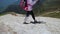 hiker is walking over snow at top of mount, woman with trekking poles is traveling and exploring