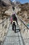 Hiker walking on a suspended metal bridge