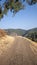 Hiker walks along dirt road through mountains