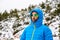 Hiker walks down the mountain during a snow covered in a down coat