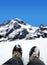 The hiker in a winter mountain landscape. Hiking shoe on legs.