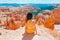 Hiker woman in Bryce Canyon resting enjoying view in beautiful nature landscape with hoodoos, pinnacles and spires rock