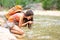 Hiker woman drinking water from river creek hiking