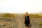 Hiker woman exploring dry region of Lanzarote Island. Young female backpacker with straw hat walking in desolate path of Lanzarote