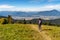 HIker woman on top of the hill walking on mountain trail