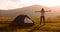 Hiker woman on top of mountain with open hands welcomes sunset