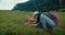 Hiker woman on tourist path collecting mushrooms at mountain meadow