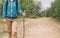 Hiker woman walking with a wooden stick in forest