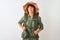 Hiker woman wearing backpack hat and water canteen over isolated white background smiling looking to the side and staring away