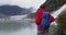 Hiker woman wearing hiking backpack in Alaska looking at glacier landscape