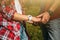 Hiker young woman holding man`s hand on nature outdoor. Couple in love, focus in hands