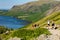 Hikers ascending England\\\'s talltest mountain, Scafell Pike via Wasdale Head with Wastwater in