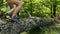 Hikers boots jumping over fallen tree