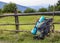 Hikers camping backpack leaning on old wooden fence. Tourist equipment