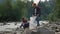 Hikers cleaning river shore from plastic. Joyful man and woman picking trash