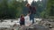 Hikers cleaning river shore from plastic. Joyful man and woman picking trash