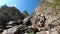 Hikers climb a steep and difficult rocky path in the Italian Alps. Trail for experienced hikers. Path to the Benigni retreat