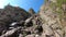 Hikers climb a steep and difficult rocky path in the Italian Alps. Trail for experienced hikers. Path to the Benigni retreat