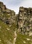 Hikers Climb Steep Path Between Rock Formations